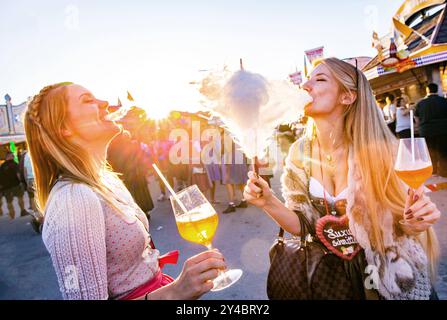 Zwei junge Frauen Freundinnen beißen gemeinsam in eine Zuckerwatte mit Aperol Spritz in der Hand auf dem Oktoberfest Wiesn in München Alkohol Spass Freude Ausgelassenheit Sonne Sonnenschein Süßes Lebensfreude Blondinen Dirndl Tracht / Datum: 21.09.2019 / *** zwei junge Freundinnen beißen zusammen zu einer Zuckerwatte mit Aperol Spritz in den Händen beim Oktoberfest Wiesn in München Alkohol Spaß Freude Ausgelassenheit Sonnenschein Sonnenschein süße Lebensfreude Sonnenschein süße Lebensfreude Lebensfreude Lebensfreude Kostüm Blondinen Blondinen Dirndl 21 09 2019 Stockfoto