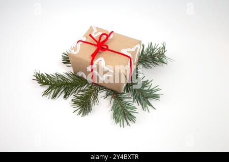 Geschenk in braunem Papier mit weißem Sternenmuster aus gefalteter Toilettenpapierrolle, gebunden mit hellrotem Band. Einzigartige, festliche Verpackung mit h Stockfoto