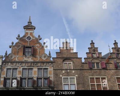 Historische Backsteingebäude mit verzierten Giebeln und roten Rollläden vor blauem Himmel, nijmegen, niederlande Stockfoto