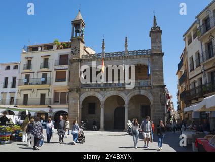 Lebhafter Platz mit historischem Gebäude, Uhrenturm und vielen Menschen bei sonnigem Wetter, Rathaus, Abuelo Mayorga Figur, Plaza Mayor, Plasencia, Cacere Stockfoto