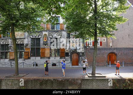 Historisches Stadtzentrum von Delft, Touristen fotografieren Gemeenlandshuis van Delfland, Rathaus, ältestes Steinhaus in Delft, in gotischer Architektur Stockfoto