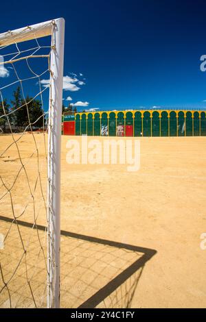 Ein einzigartiger Blick auf eine tragbare Stierkampfarena in Aznalcazar, Sevilla, Spanien, mit einem Fußballtor im Vordergrund unter einem klaren blauen Himmel. Stockfoto