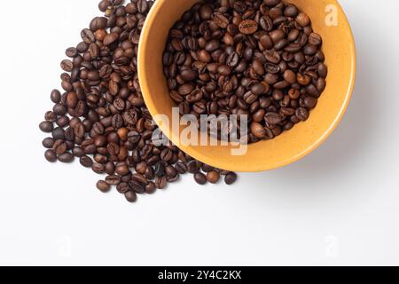 Gelbe Frühstücksschale gefüllt mit Kaffeebohnen Stockfoto
