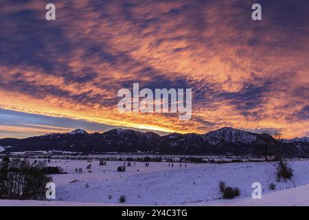 Sonnenaufgang, Wolken über den Bergen, Winter, Schnee, Loisach-Lake Kochel Moor, Kochler-Berge dahinter, Bayern, Deutschland, Europa Stockfoto