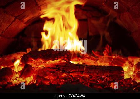 Feuer und brennende Feuerhölzer im Ofen aus nächster Nähe Stockfoto