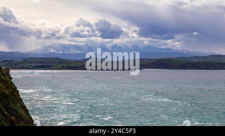 Panoramablick auf die kantabrische Küste mit den Picos de Europa im Hintergrund. Stockfoto