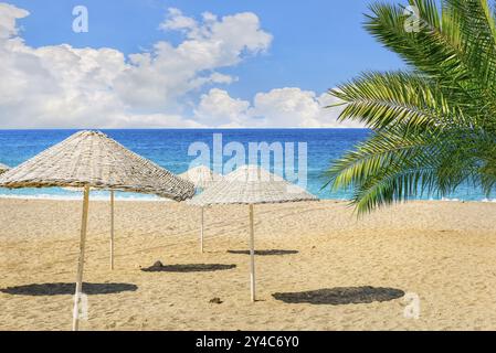 Korbschirme am Sandstrand am Meer Stockfoto