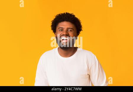 Freudige african american Kerl über orange Hintergrund Stockfoto