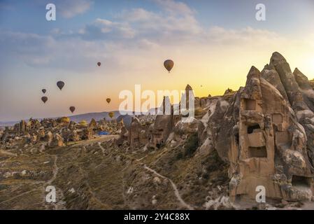 Luftballons über konischen Klippen in Kappadokien bei Sonnenaufgang, Türkei, Asien Stockfoto