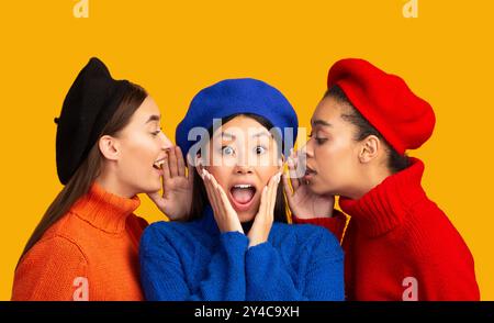 Diverse junge Frauen teilen Klatsch auf gelben Hintergrund, Panorama Stockfoto