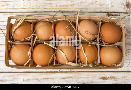 Weideneierschale voll mit frischen Eiern auf einem hölzernen Tabelle Stockfoto