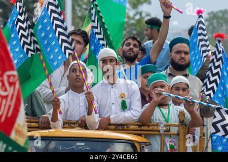 Srinagar, Indien. September 2024. Kaschmiri-Muslime halten islamische Fahnen, während sie an einer religiösen Prozession anlässlich der Eid-e-Milad teilnehmen, um den Geburtstag des Propheten Mohammed (PBUH) am Stadtrand von Srinagar zu gedenken. EID-e-Milad-un-Nabi, oder (Mawlid), ist das islamische fest, das den Geburtstag des Propheten Mohammed (PBUH) feiert, der am 12. Tag von Rabi-ul-Awwal, dem dritten Monat des islamischen Kalenders im Jahr 571 n. Chr. in der Saudi-arabischen Stadt Mekka geboren wurde. Credit: SOPA Images Limited/Alamy Live News Stockfoto