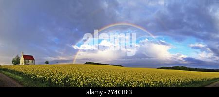 Panorama, Kapelle und Regenbogen über einem Rapsfeld Stockfoto