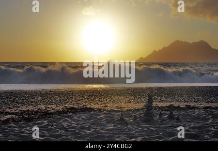 Landkunst vor den Surfwellen bei Sonnenuntergang am Strand von Porto, Korsika Stockfoto