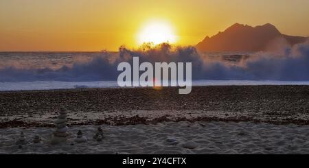 Landkunst vor den Surfwellen bei Sonnenuntergang am Strand von Porto, Korsika Stockfoto