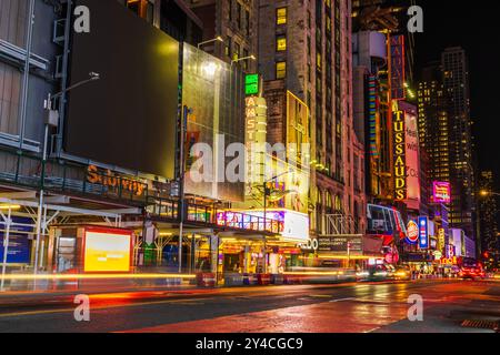 Wunderschöner Blick auf Lichtspuren von den Autoscheinwerfern mit Madame Tussauds Plakatwänden und Straßenbeleuchtung bei Nacht. New York. USA. Stockfoto