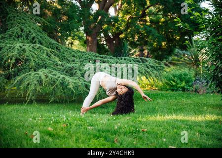 Eine brünette Frau in Sportbekleidung, die Halasana-Yoga-Haltung oder Pflugposition macht Stockfoto