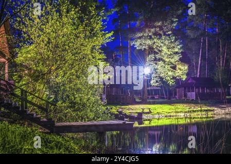 Holztreppe zum Teich in der Nähe von Hütten im Wald Stockfoto