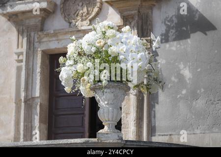 Romantischer Hochzeitsstrauß in einer barocken Steinvase vor der Chiesa di San Giuseppe in Taormina in Sizilien, Italien, Europa Stockfoto