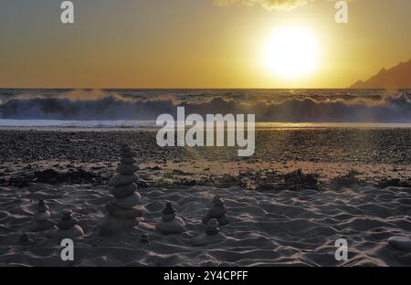 Landkunst vor den Surfwellen bei Sonnenuntergang am Strand von Porto, Korsika Stockfoto