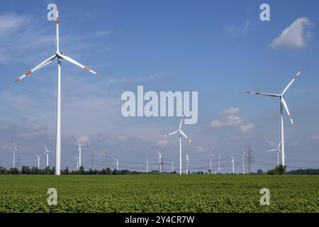 Windturbinen mit Stromleitungen im Hintergrund, gesehen in Deutschland Stockfoto