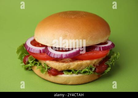 Köstlicher veganer Burger mit Kichererbsenkotelett auf grünem Hintergrund Stockfoto