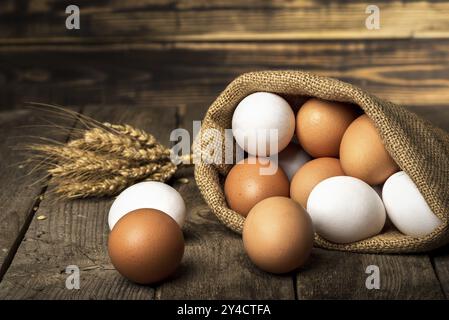 Die Eier im Sack und die Garbe des Weizens auf dem alten Holztisch Stockfoto