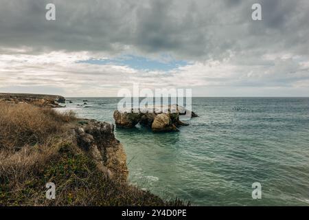 Montana de Oro, Kalifornien. Felsen entlang der Küste und dramatisch bewölkter Himmel im Hintergrund. Sonnenuntergang über dem Pazifik Stockfoto