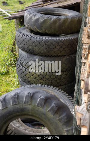 Traktor und Auto legen alte Reifen in einen Stapel Stockfoto