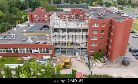 Baustelle eines mehrstöckigen Gebäudes mit freiliegenden Böden und Gerüsten. Materialien wie Isolierungen und Betonblöcke sind sichtbar und präsentieren Stockfoto