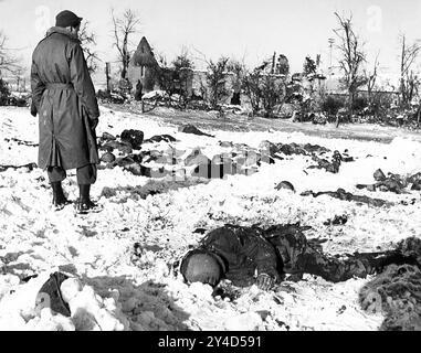 MASSAKER VON MALMEDY. Ein amerikanischer Soldat mit Leichen seiner Kameraden, die am 17. Dezember 1944 von der Waffen-SS an der Kreuzung Baugnez in der Nähe der Stadt Malmedy in Belgien getötet wurden. Stockfoto