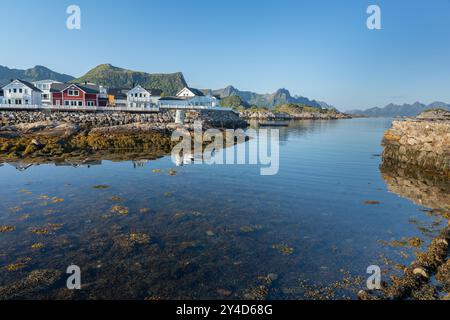 Häuser am felsigen Ufer mit Bergen im Hintergrund in Kabelvag, Lofoten Norwegen Stockfoto