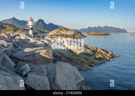 Leuchtturm am felsigen Ufer mit Inseln und Bergen im Hintergrund in Kabelvag City, Lofoten Norwegen Stockfoto