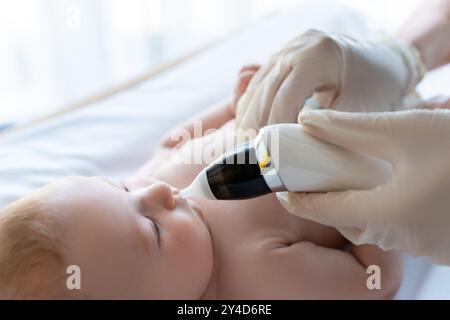 Der Kinderarzt untersucht die Nase eines kleinen Mädchens oder Jungen Stockfoto