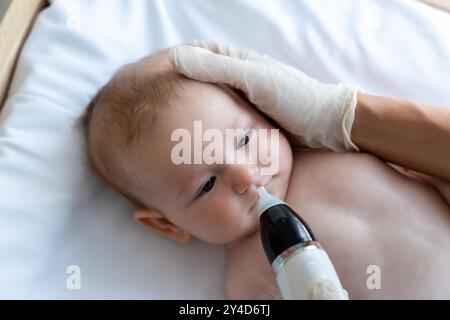 Der Kinderarzt untersucht die Nase eines kleinen Mädchens oder Jungen Stockfoto