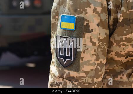 Militärabzeichen der ukrainischen Armee mit Dreizack und gelb-blauer Flagge auf der Uniform eines ukrainischen Soldaten Nahaufnahme Stockfoto