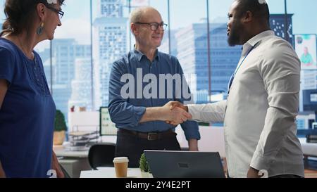 Senior People berät Finanzberater über Altersvorsorge- und Rentenplanung und schüttelt die Hand, um die Zukunft mit Lebensversicherungen und Sparen zu sichern. Finanzielle Möglichkeiten im modernen Büro. Kamera B.. Stockfoto