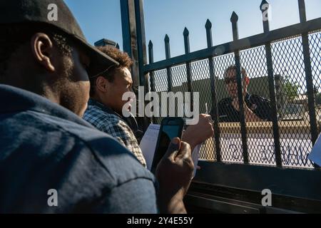 Sacramento, Kalifornien, USA. August 2024. SAMUEL LE, links, ein Bewohner des Camp Resolution, spricht durch ein verschlossenes Sicherheitstor zu Sacramento Feuermarschall Jason Lee, rechts, der dort war, um das Lager erneut zu inspizieren. Lee sagte, er sei da, um zu helfen und den Campern, falls nötig, mehr Zeit zu bieten, wenn sie es brauchten. Obwohl sie die Inspektion bestanden haben, schloss die Stadt Sacramento das Lager. (Kreditbild: © Renee C. Byer/ZUMA Press Wire) NUR REDAKTIONELLE VERWENDUNG! Nicht für kommerzielle ZWECKE! Stockfoto