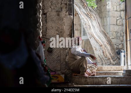 Lalisch, Irak. September 2024. Ein Mann sitzt am Eingang des Tempels von Lalish. Lalish ist die heiligste Stätte der Jesiden. Quelle: Hannes P. Albert/dpa/Alamy Live News Stockfoto