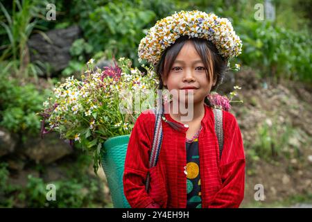 Das lokale Hmong-Mädchen verkauft Blumen entlang der Ha Giang Loop in den Bergen Nordvietnams Stockfoto