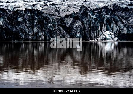 Solheimajokull-Gletscher bedeckt mit Ruß von früheren Eruptionen, wobei der Gletschersee vom Vulkan bei Vik in Island absteigt Stockfoto