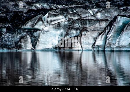 Solheimajokull-Gletscher bedeckt mit Ruß von früheren Eruptionen, wobei der Gletschersee vom Vulkan bei Vik in Island absteigt Stockfoto