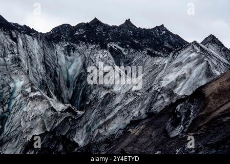 Solheimajokull-Gletscher bedeckt mit Ruß von früheren Eruptionen, wobei der Gletschersee vom Vulkan bei Vik in Island absteigt Stockfoto