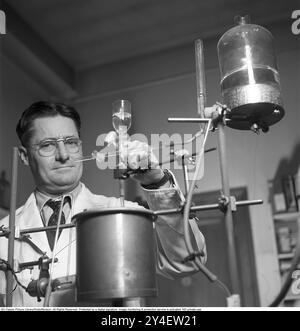 Howard Florey. 1898-1968. Australischer Pharmakologe, der 1945 den Nobelpreis für Physiologie oder Medizin mit Alexander Fleming und Ernst Chain erhielt. Obwohl Fleming den größten Teil der Anerkennung für die Entdeckung von Penicillin erhielt, waren es Florey und sein Team an der University of Oxford, die es zu einer nützlichen und wirksamen Droge machten, zehn Jahre nachdem Fleming seine Entwicklung aufgegeben hatte. Abgebildet im Labor des St. Marys Krankenhauses. KG Kristoffersson Ref. S85-5. (Gescannt von seinem negativen Original, auf Anfrage im Großformat erhältlich.) Kristoffersson war damals einer der jüngsten Kriegsfotografen Stockfoto