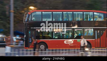 Mumbai, Indien. Doppeldeckerbus fährt die Straße in Mumbai. Abenddämmerung In Der Stadt. Motorräder Und Autos Fahren Abends Auf Der Straße. Das Tägliche Leben Indiens Stockfoto