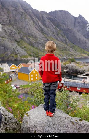 Typische Rourbuer Fischerhütten im Dorf Lofoten Nusfjord an einem regnerischen Tag, im Sommer. Traditionelles norwegisches rotes Holzhaus Stockfoto