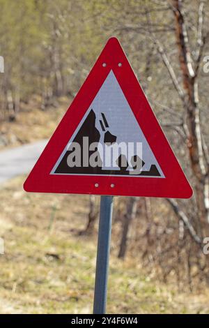 Ein rotes Dreieckszeichen, das auf einem weißen Hintergrund herabfallende Felsen anzeigt. Stockfoto