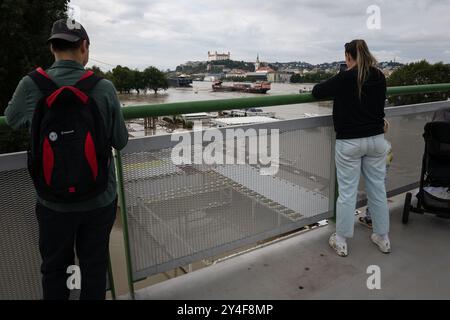 BRATISLAVA, SLOWAKEI - 17. SEP 2024: Die Menschen beobachten den Anstieg der Donau von der Alten Brücke in Bratislava, Slowakei Stockfoto