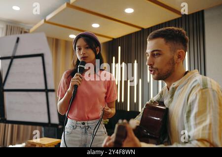 Singende Frau und Gitarrist im Studio-Setting Stockfoto