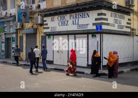 Dschibuti: Atmosphäre in der Altstadt, Gruppe verschleierter Frauen in traditionellem Outfit, vorbei an einem Kleiderladen 'Au Chic Parisien, chez Ali' in der Rue de Pa Stockfoto